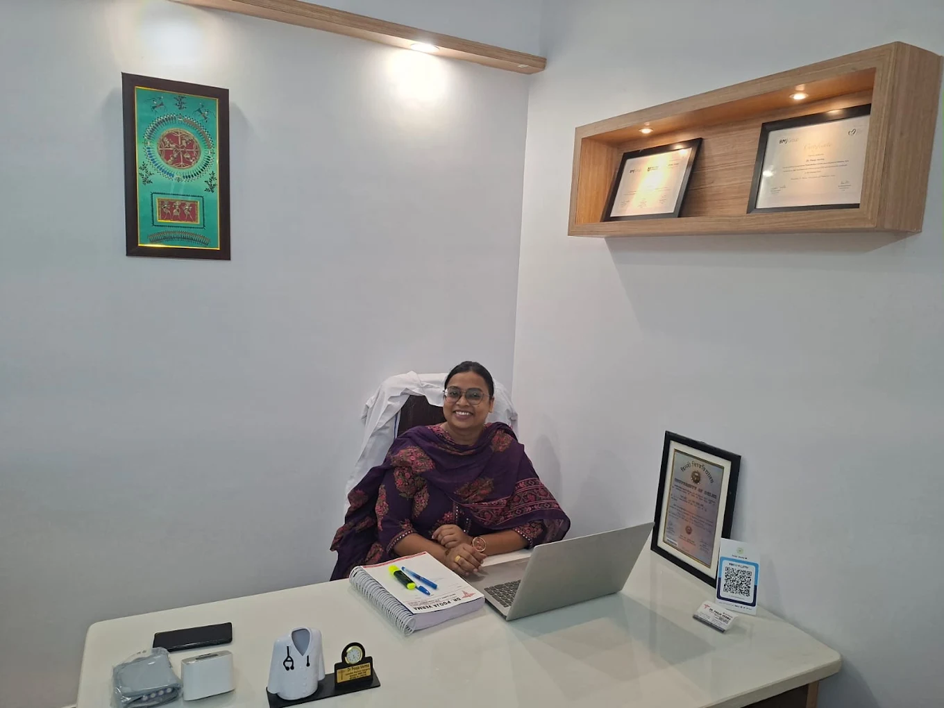 Dr. Pooja Verma seated at her consultation desk in the clinic